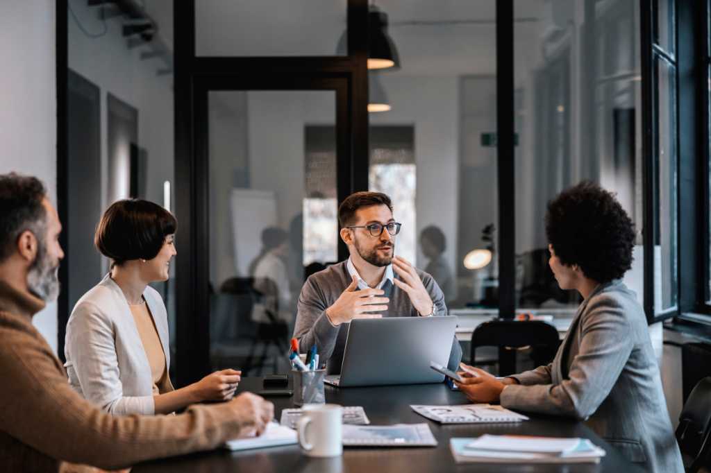 Mentor talking to his team at a meeting