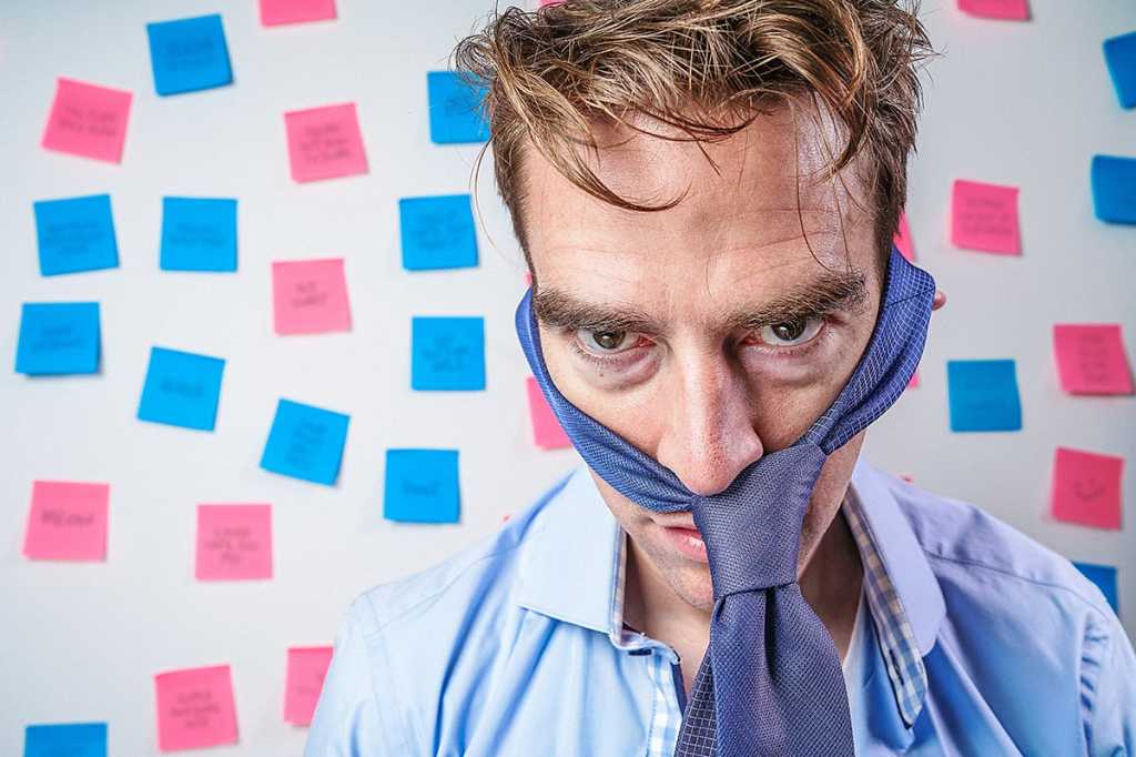 a burned out, frazzled man in disheveled shirt and tie