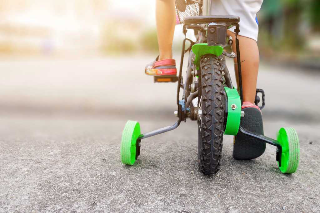 shutterstock 1175637019 learning to ride a bike training wheels