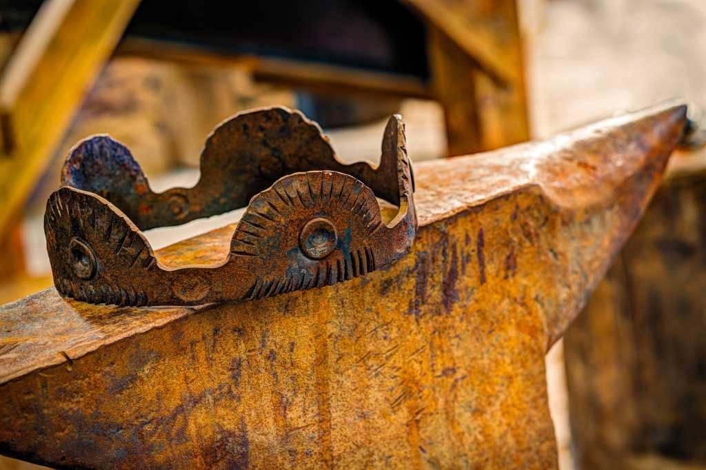 A rusty crown sits on an anvil.