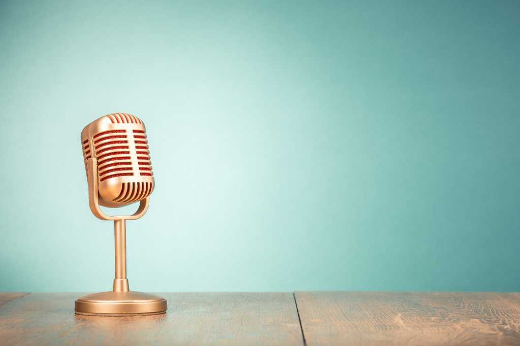 News, news reporting. Old-fashioned microphone sits on a desk.